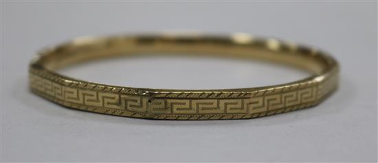 An engraved 9ct gold bangle.